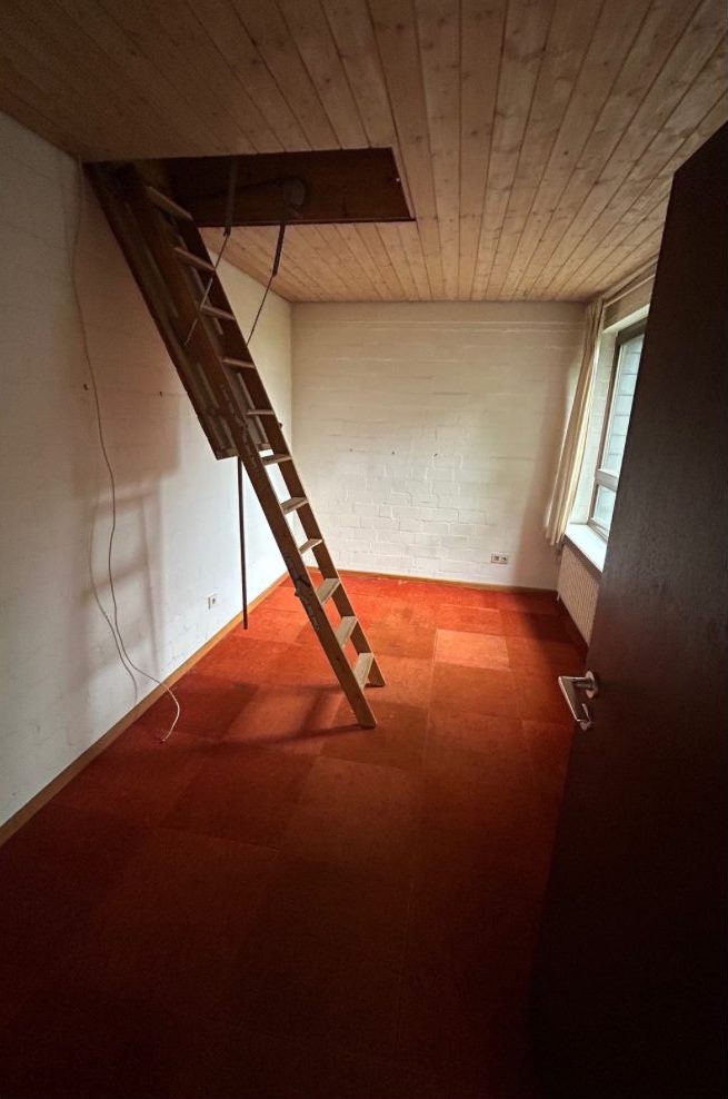 Leeres Zimmer mit Dachbodenleiter